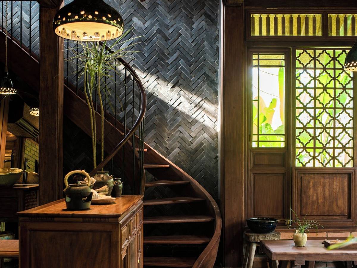 Spa entrance with a spiral wooden staircase, stone wall, lantern and latticed window